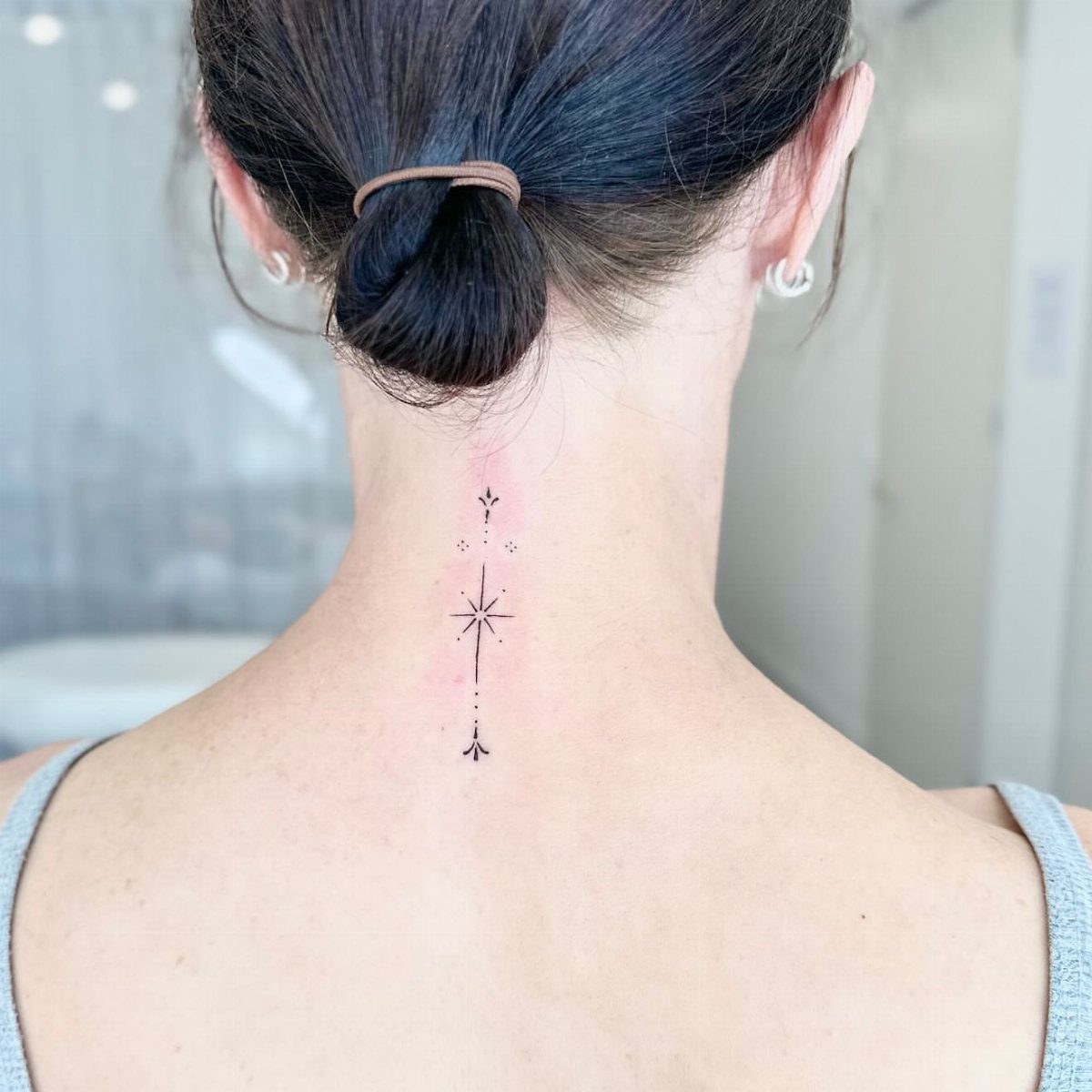 Fine Line Tattoo Placement: 11 Ideas That Actually Work 9 A fine line celestial star tattoo located on the back of a person's neck.