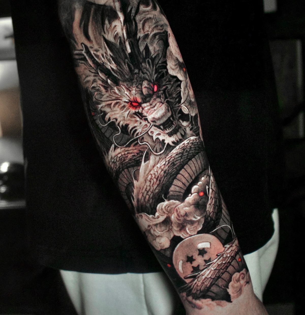 9 Tattoo Style Anime Ideas for Your First Ink or Next Sleeve 3 A detailed blackwork dragon tattoo with red eyes winding around a person's arm.