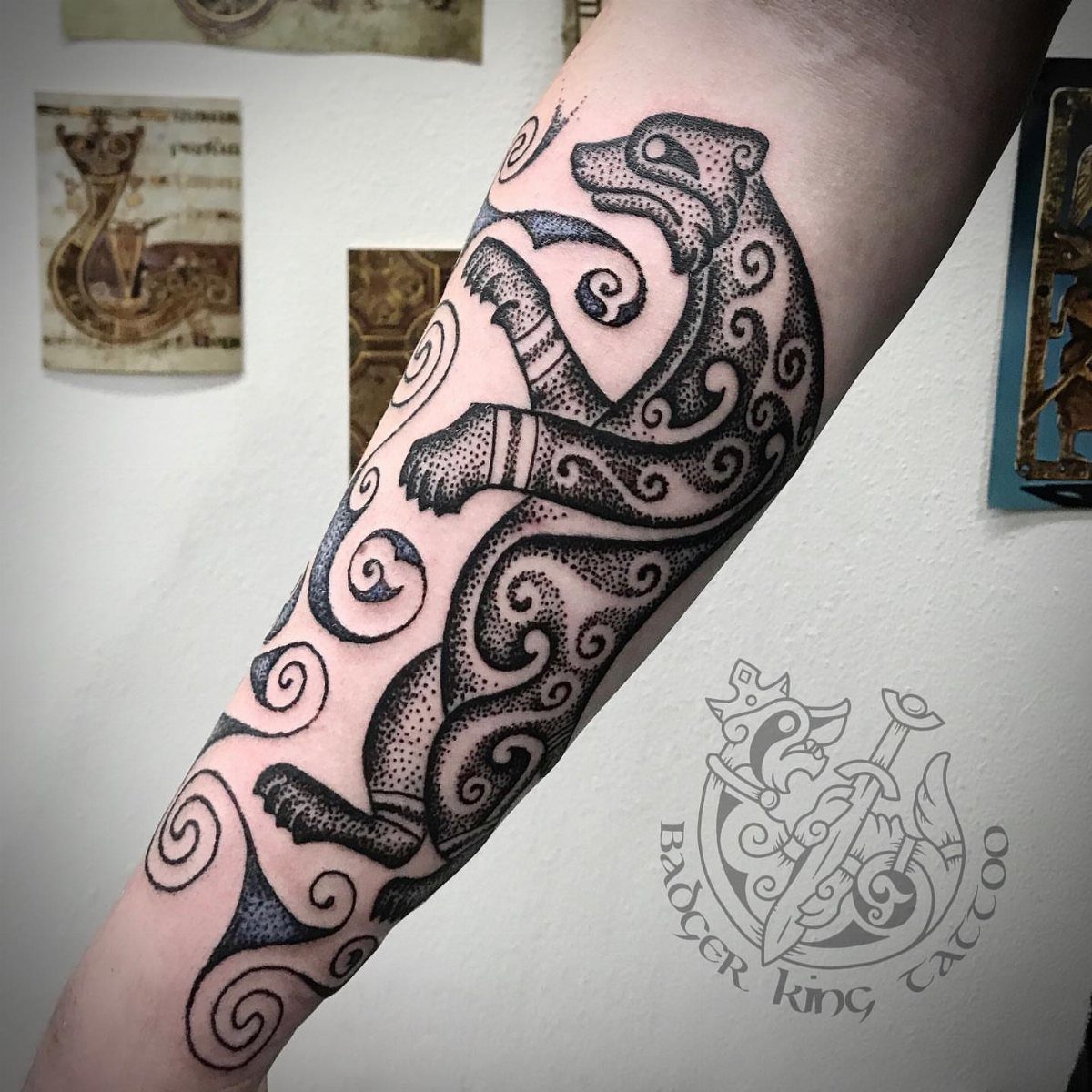 Celtic Pagan Tattoo: 6 Design Ideas and Flash Art 4 A black ink Celtic knotwork tattoo of a stylized animal on a person's forearm.