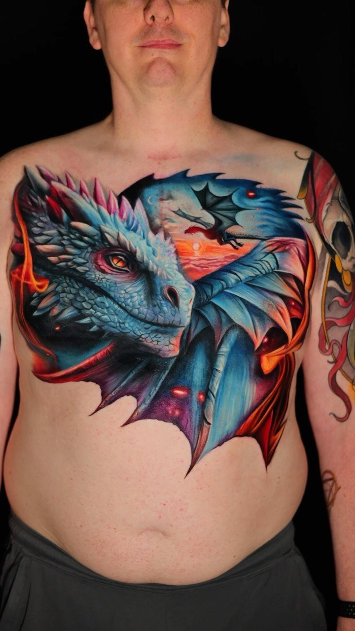 Tattoo Pattern Dragon: 11 Ideas for Ink That Follows the Body 8 A large, colorful blue and orange dragon tattoo spanning across a man's chest.