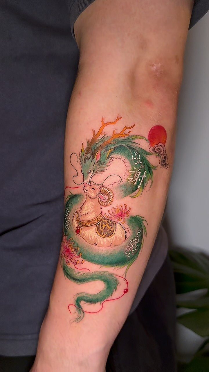 Tattoo Pattern Dragon: 11 Ideas for Ink That Follows the Body 3 A colorful green and gold Chinese dragon tattoo coiled around a person's forearm.