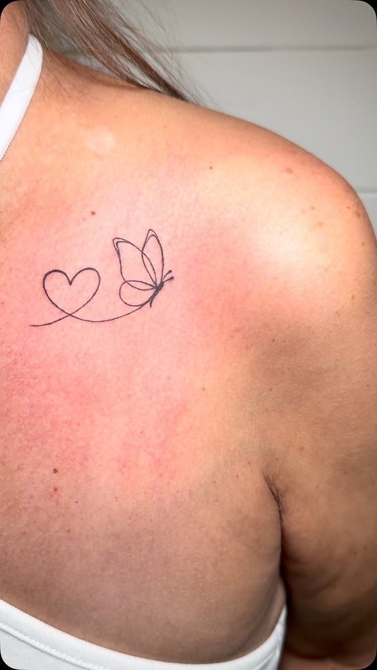Fine Line Tattoo Placement: 11 Ideas That Actually Work 8 A fine line butterfly and heart tattoo on a person's collarbone and shoulder.