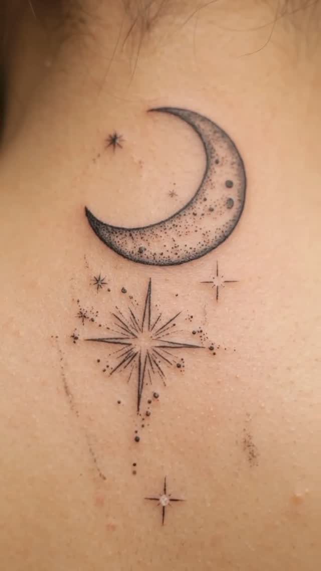 A fine line tattoo of a crescent moon and several stars on human skin.