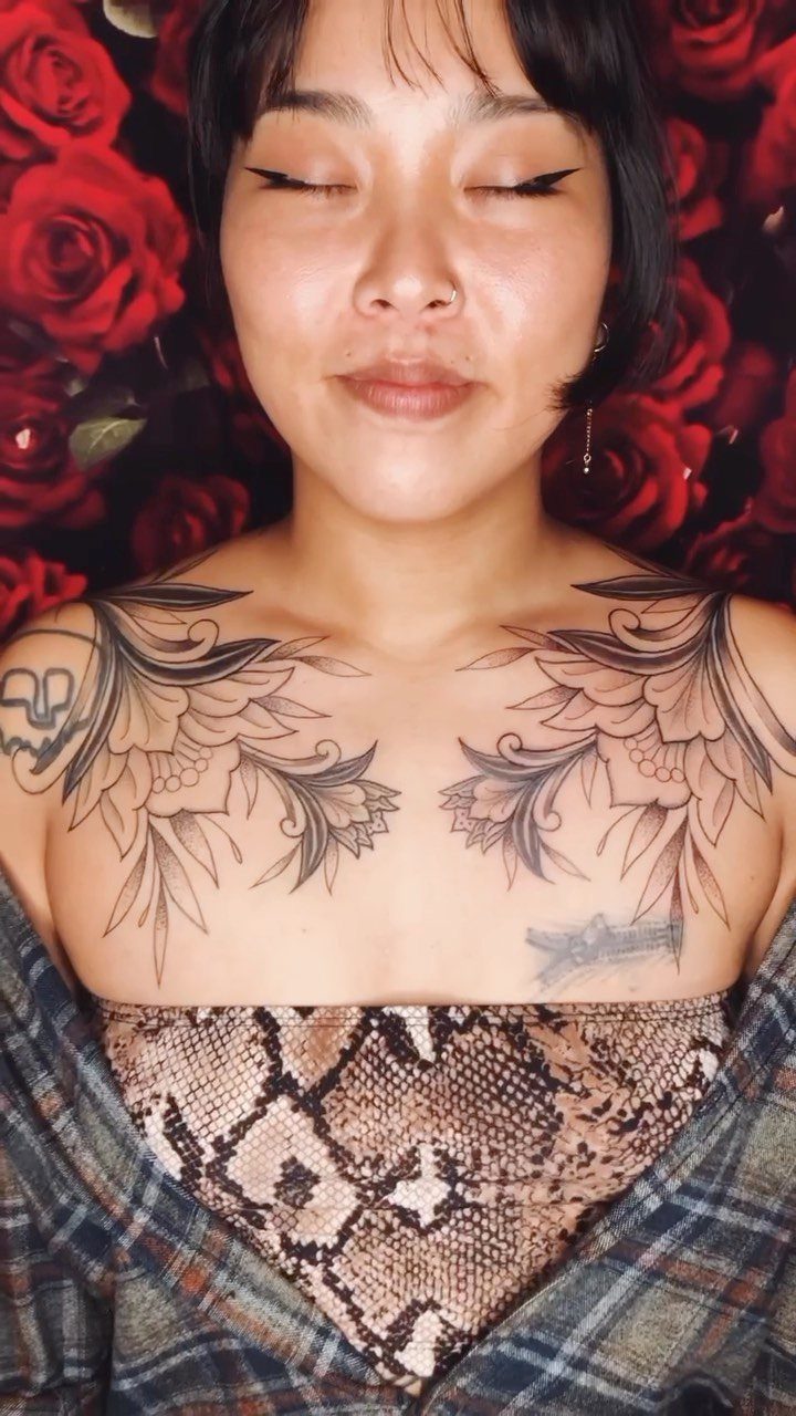 Tattoo at Chest: 15 Ideas from Wing Spread to Underboob 9 A person with large black ink floral tattoos across their upper chest and collarbone.