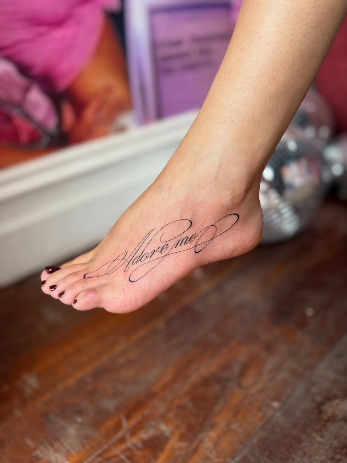 Fine Line Tattoo Placement: 11 Ideas That Actually Work 10 A foot with a fine line script tattoo reading Adore me on the side.
