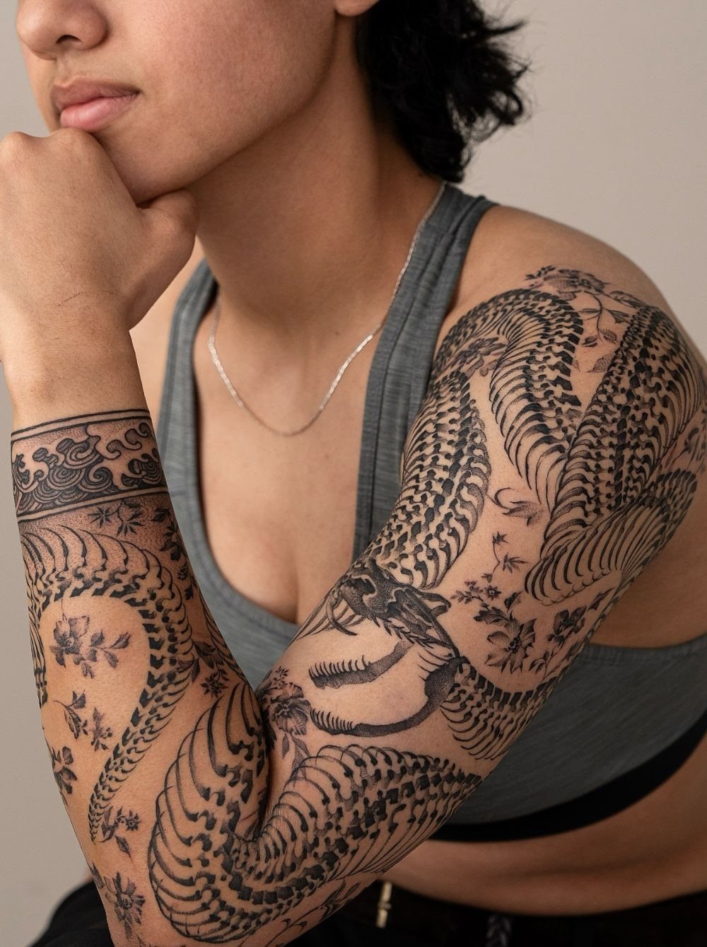Tattoo Pattern Dragon: 11 Ideas for Ink That Follows the Body 6 A person's arm featuring a large, detailed black ink dragon tattoo covering the entire sleeve.