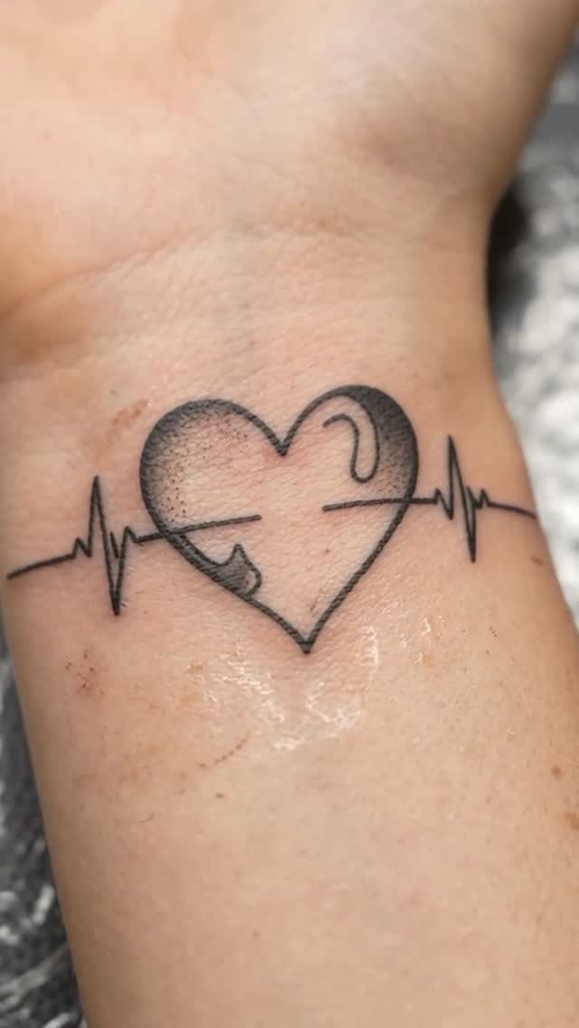 17 Tattoo Pattern on Arm Ideas: From Fine Line to Full Sleeve 13 A black ink heartbeat line tattoo with a heart shape on a person's wrist.