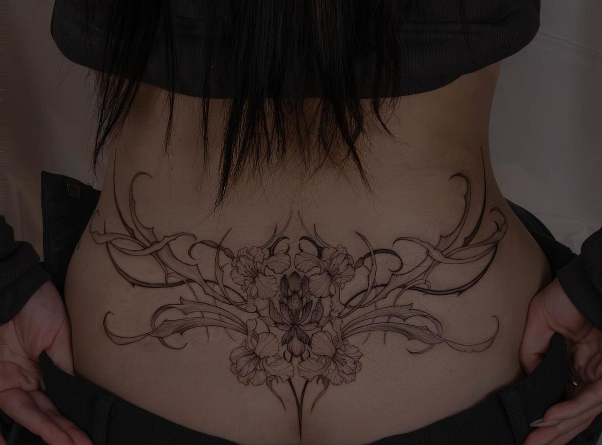 Tattoo Placement on Back: 6 Areas for Your Next Ink 7 A large floral and scrollwork tattoo spanning across a person's lower back and hips.
