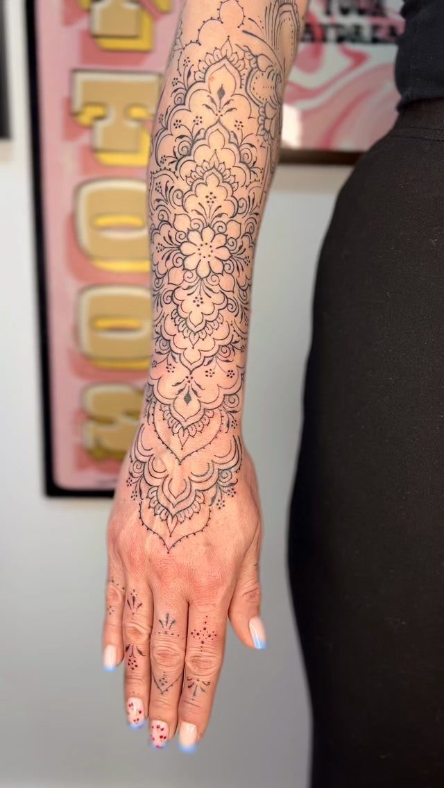 11 Tattoo Arm Women Will Want to See Before Booking 2026 11 Intricate black ink mandala tattoo design covering a woman's forearm and the back of her hand.
