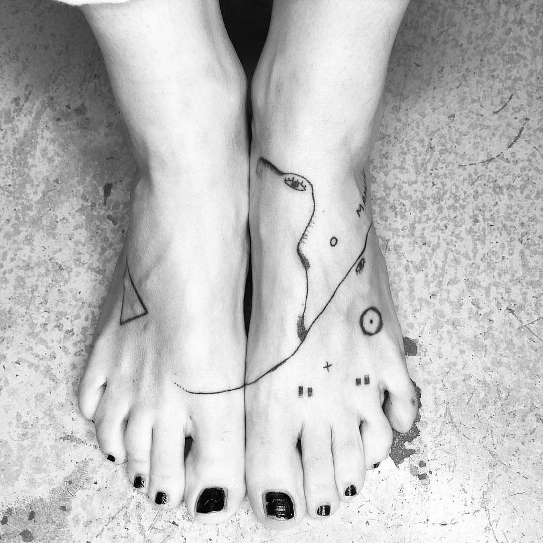 Tattoo Pattern Abstract: 10 Design Ideas for Your Next Ink 3 Minimalist black ink abstract line tattoos on a person's feet and ankles.