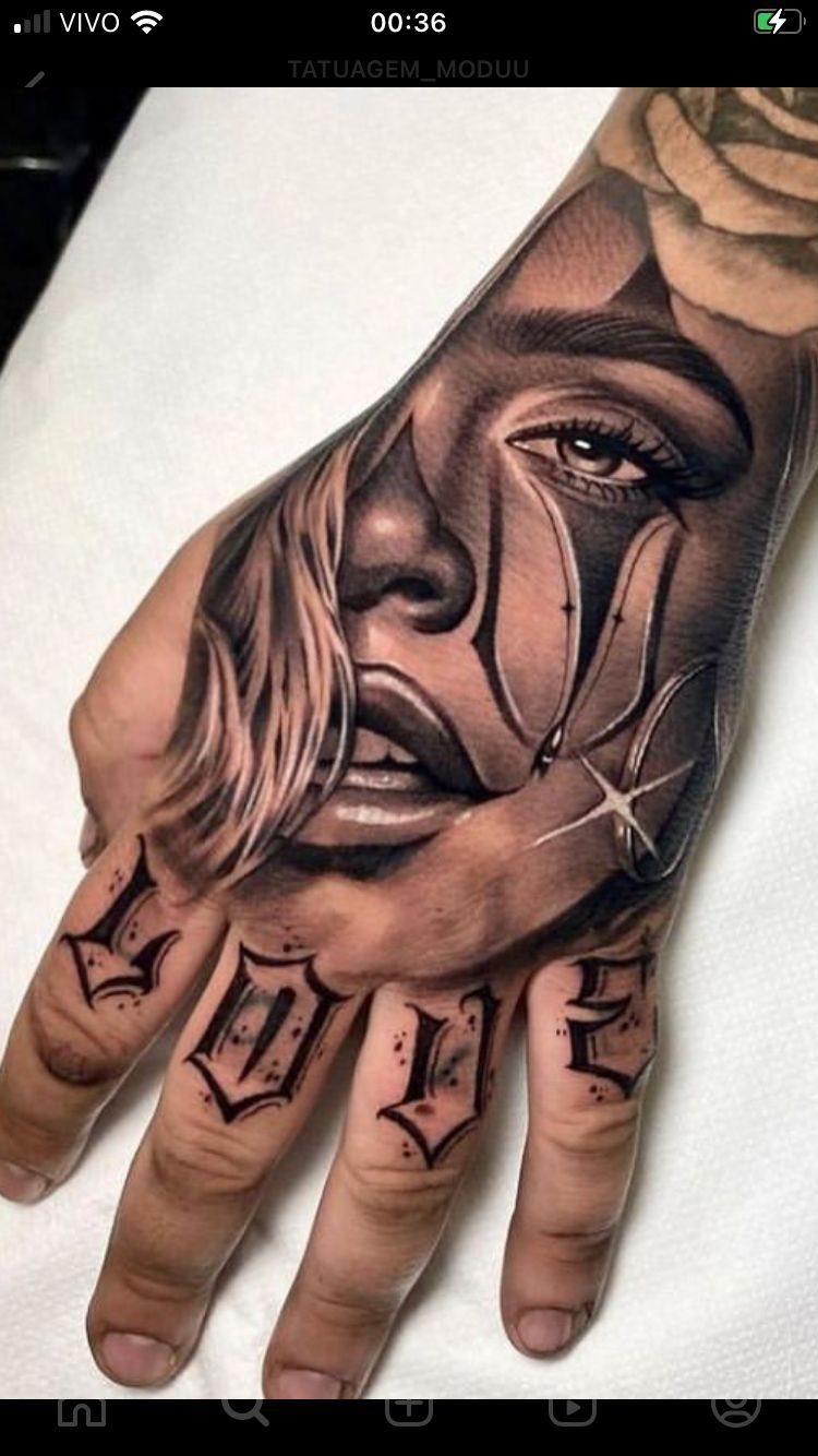Tattoo Style for Hand: 8 Designs That Work on This Spot 7 A detailed black and grey realism tattoo of a female face on a person's hand.