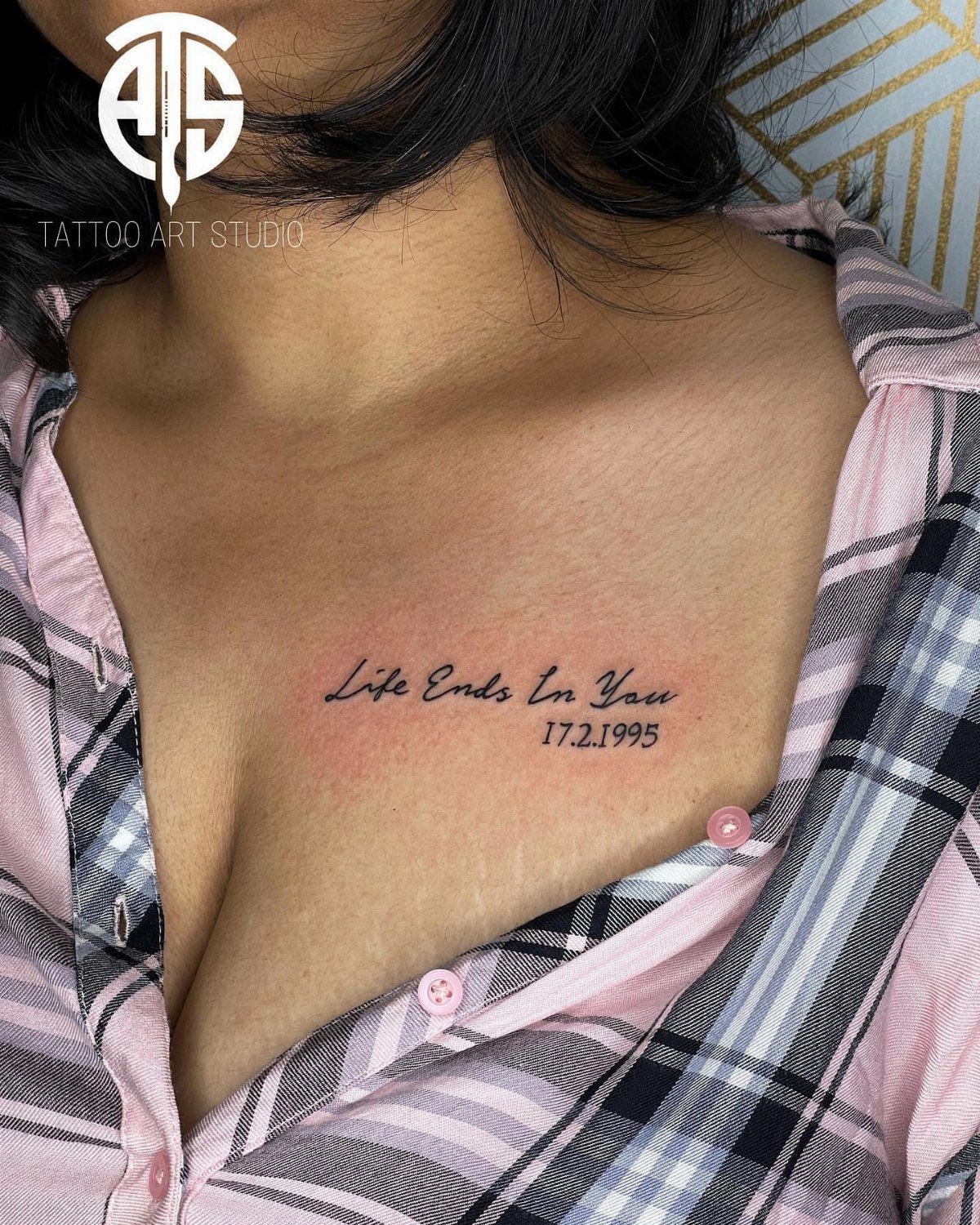 A script tattoo reading Life Ends In You and a date on a person's chest.