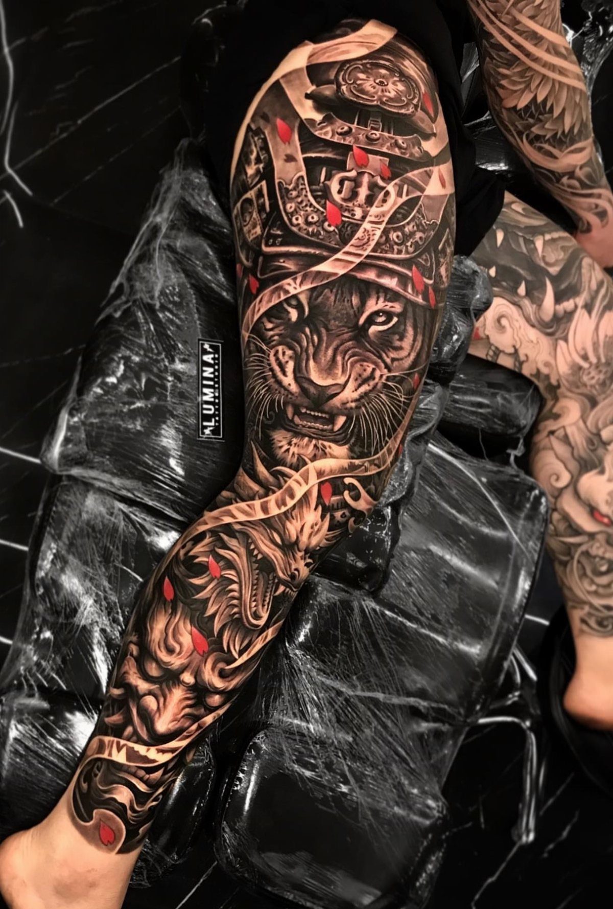7 Full Leg Tattoo Ideas for Bold Leg Sleeves 2026 8 A detailed black and grey leg sleeve tattoo featuring a tiger and ornamental patterns.