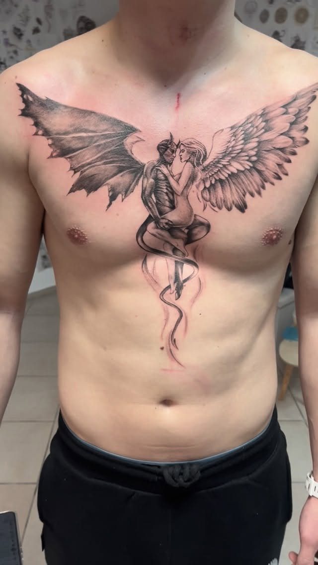 Tattoo at Chest: 15 Ideas from Wing Spread to Underboob 5 A large chest tattoo of a devil and angel with expansive wings on a man's torso.